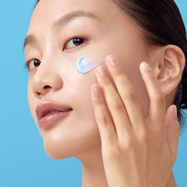 Crème bleue étalée sur la joue du bout des doigts
