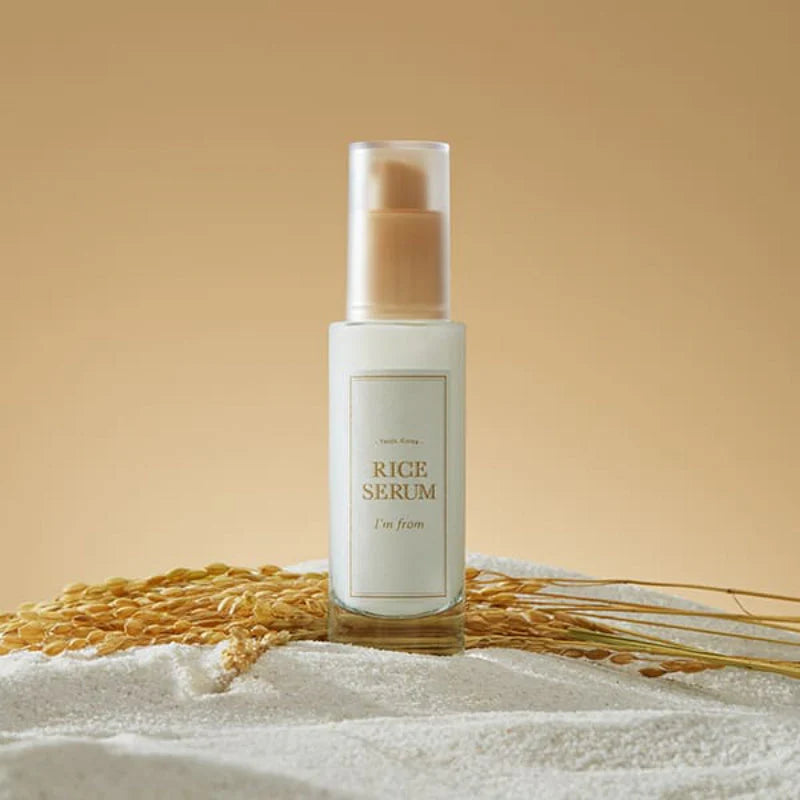 Flacon de sérum au riz posé sur une serviette avec des épis