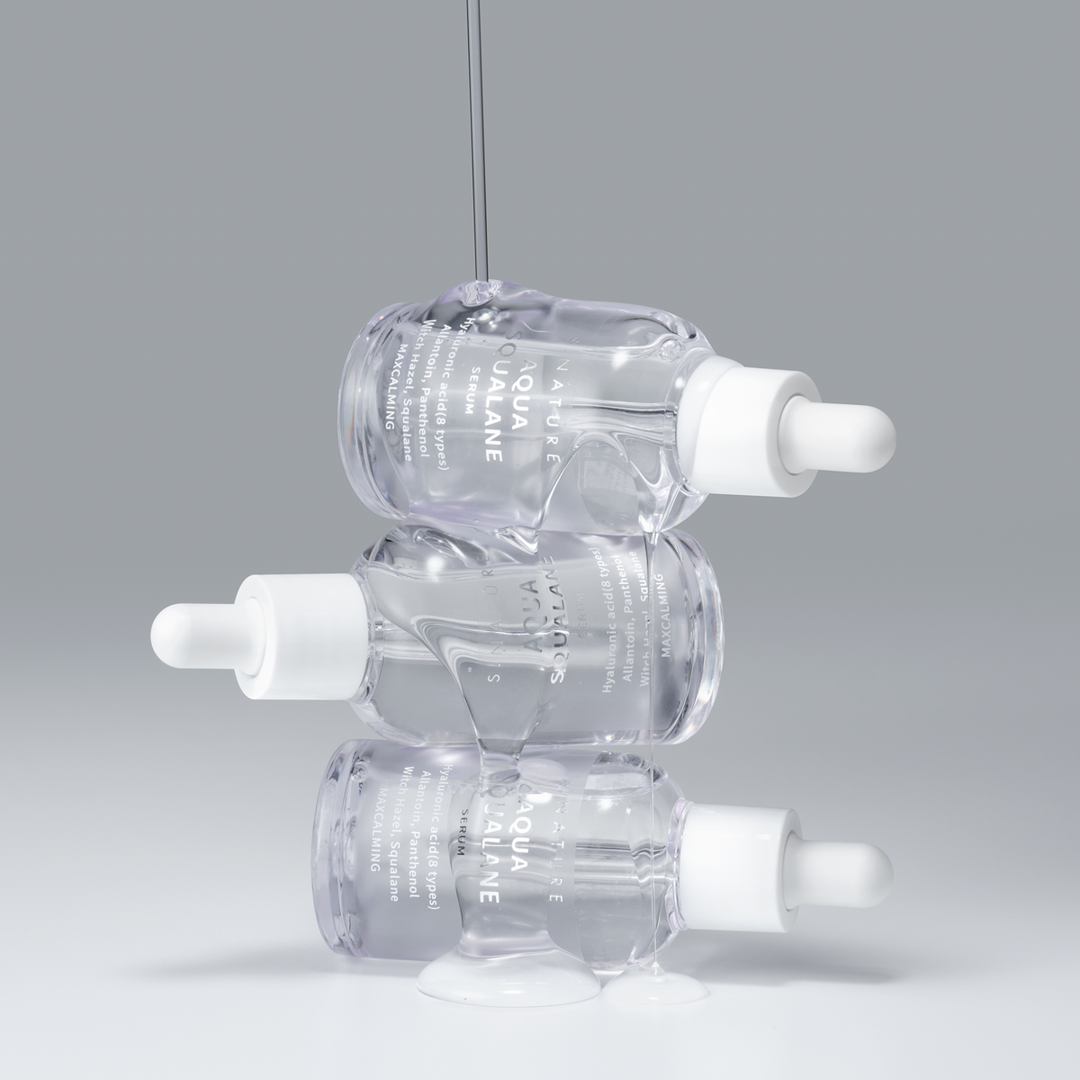Flacons de sérum à pipette blanche empilés sous un filet transparent