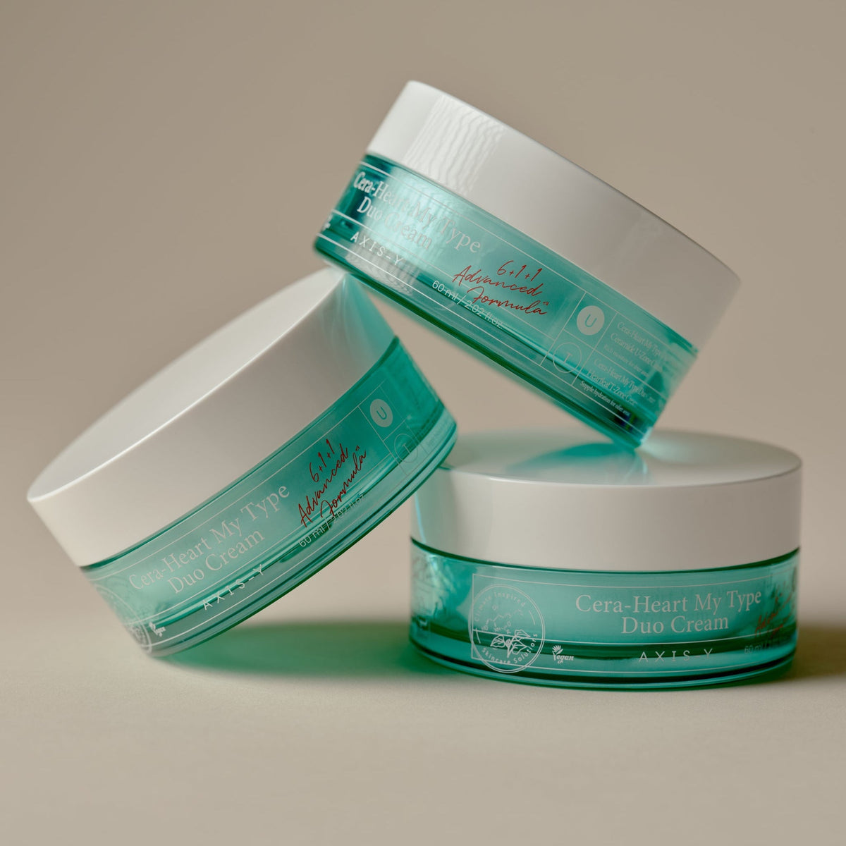 Trois pots turquoise de crème à couvercles blancs superposés