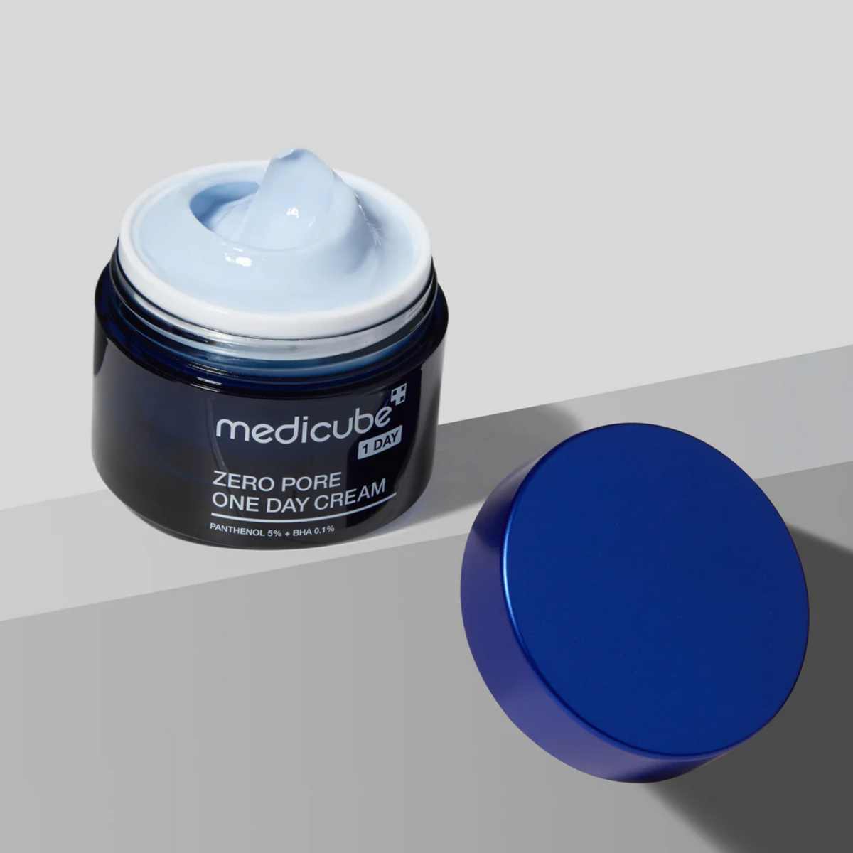 Pot bleu ouvert montrant une crème bleu pâle près de son couvercle