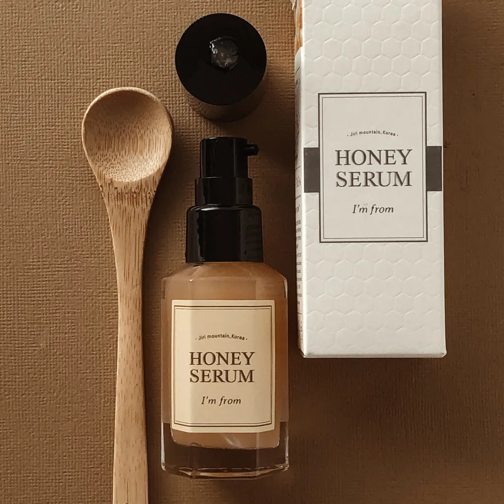 Flacon-pompe de sérum au miel près de sa boîte et d&