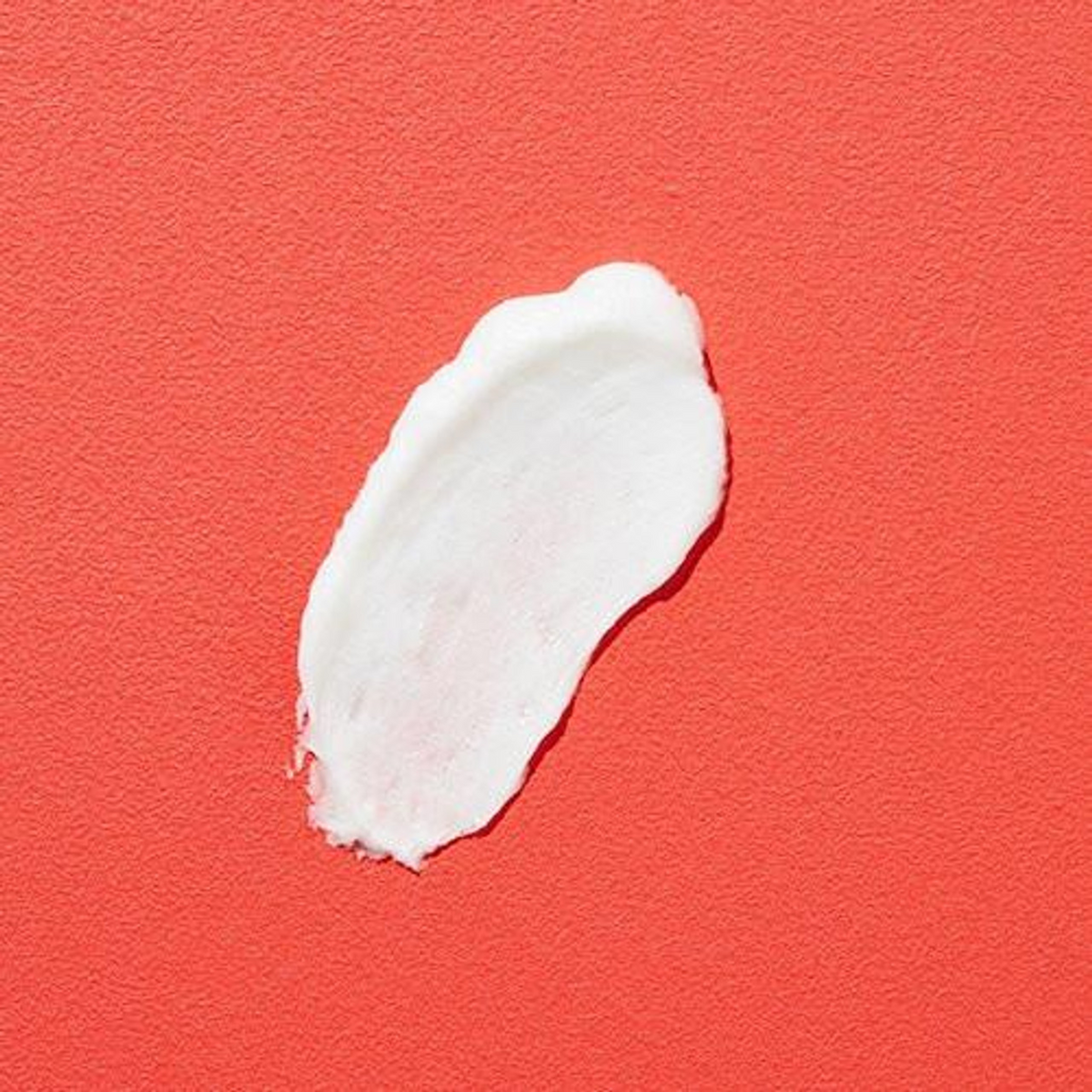 Trace de nettoyant blanc étalé sur fond rouge