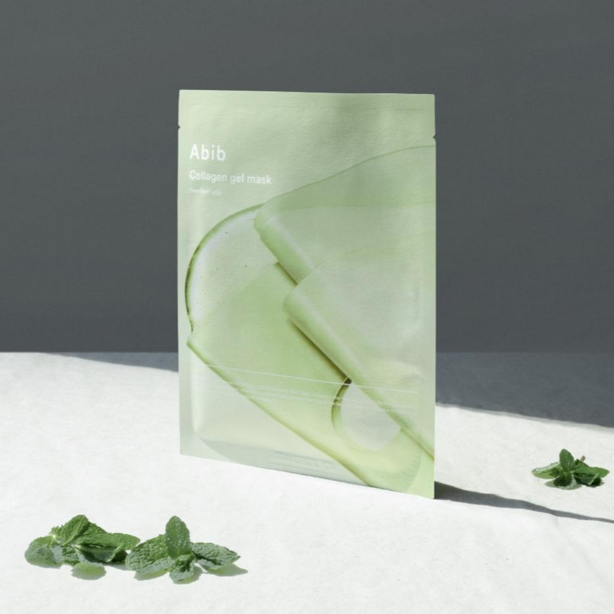 Sachet vert de masque dressé près de petites feuilles