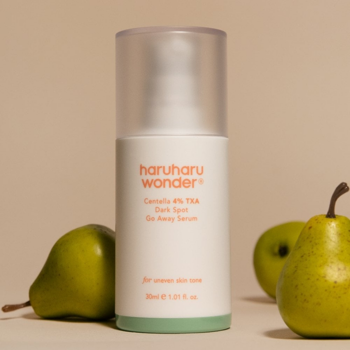 Flacon de sérum entouré de poires vertes