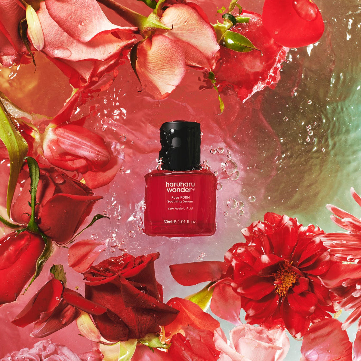 Flacon rouge de sérum entouré de roses et d&