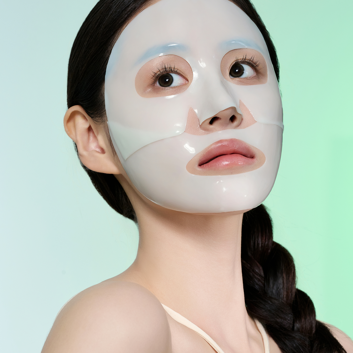 Masque hydrogel vert pâle en deux parties posé sur le visage