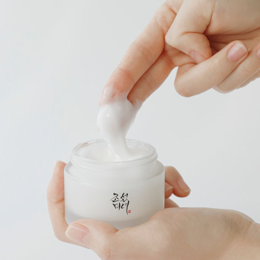 Crème blanche épaisse prélevée au doigt dans le pot