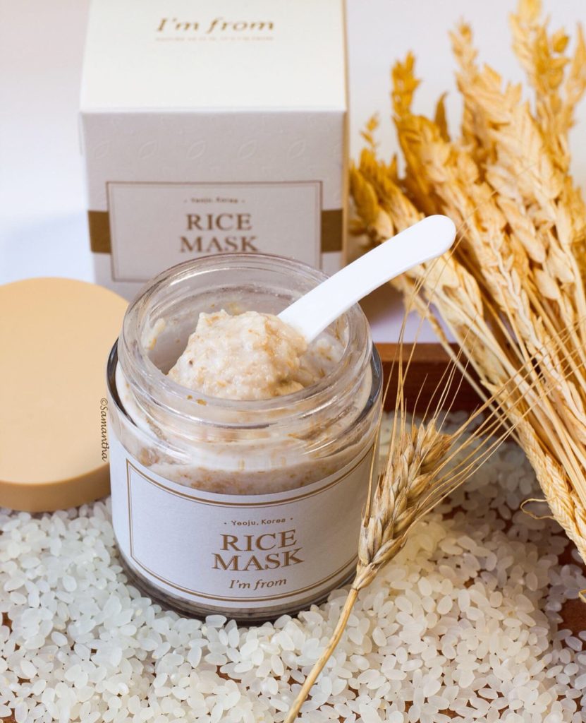 Pot ouvert de masque au riz avec spatule, grains et épis de riz