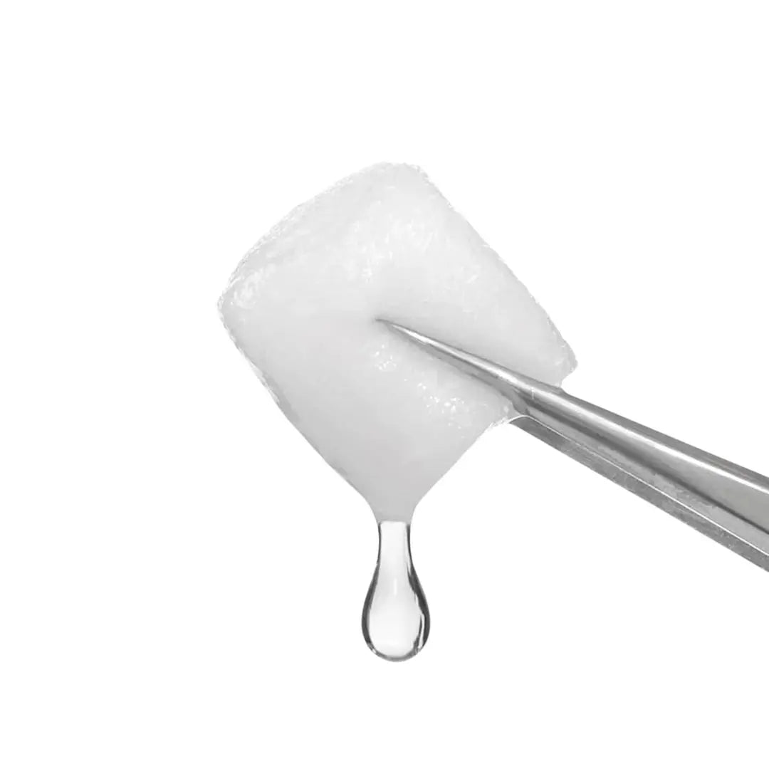 Coton imbibé de soin transparent tenu à la pince