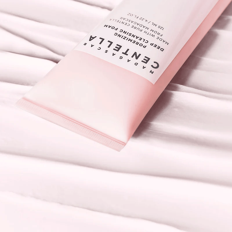 Tube rose de nettoyant sur des bandes de texture claire