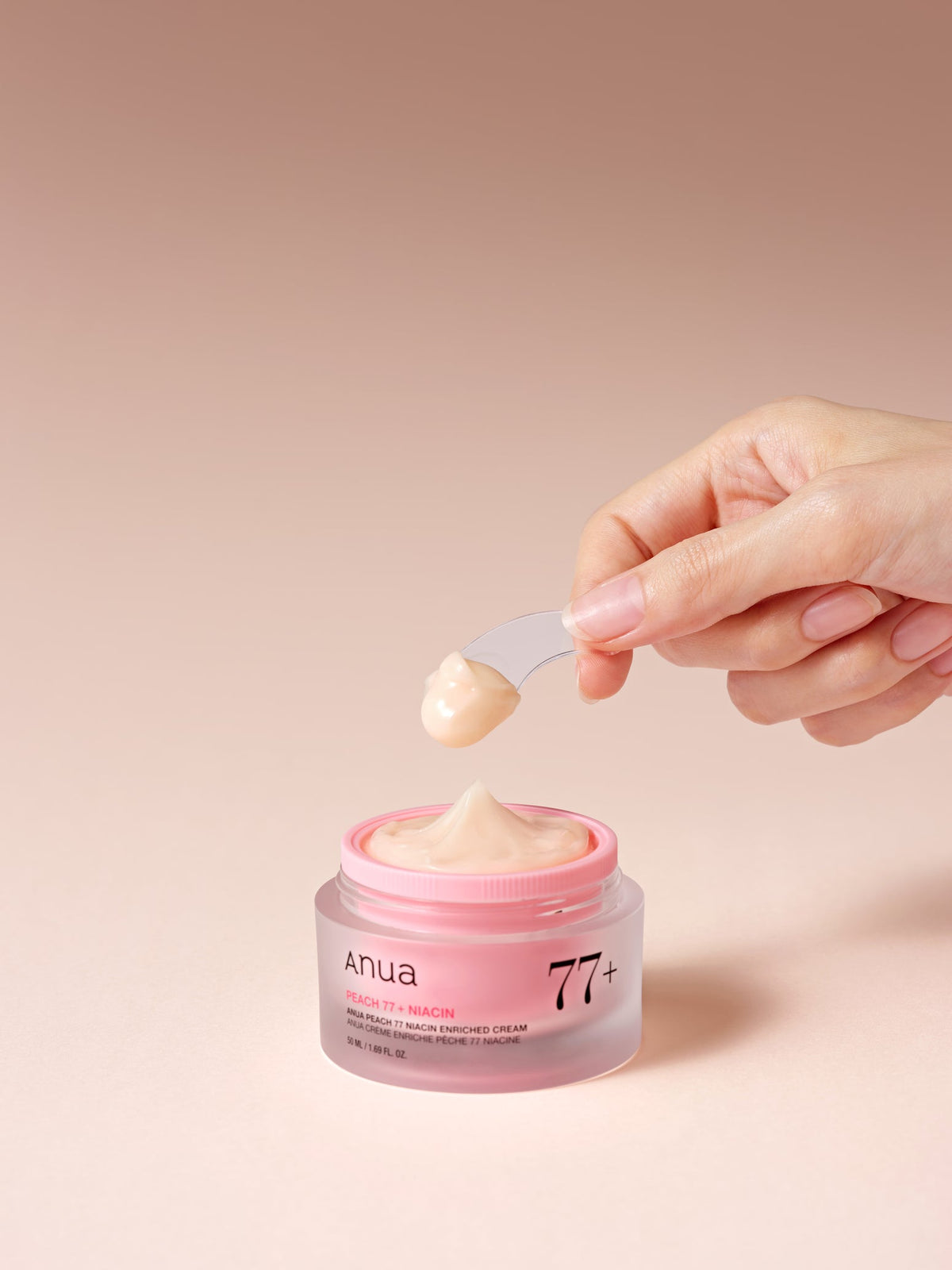 Crème prélevée à la spatule dans le pot rose