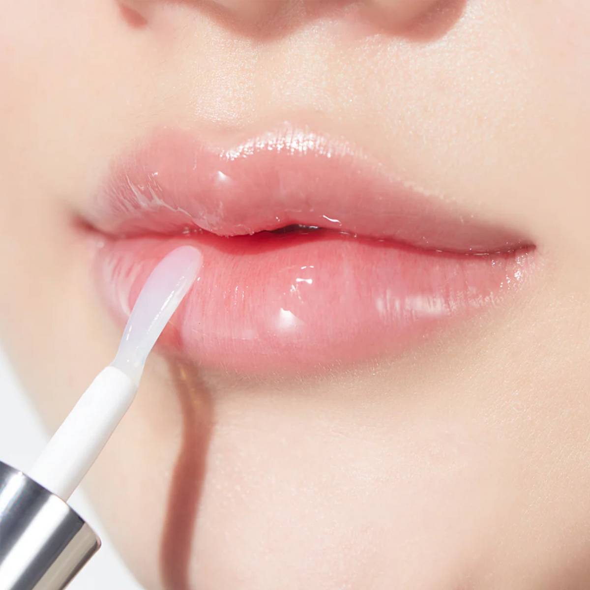 Application du gloss transparent sur les lèvres