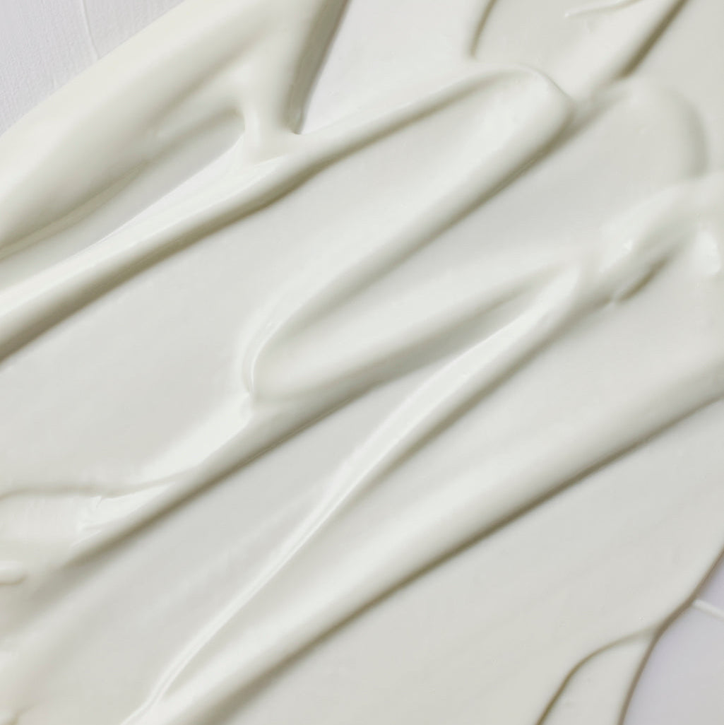 Texture blanche de sérum solaire étalée en bandes