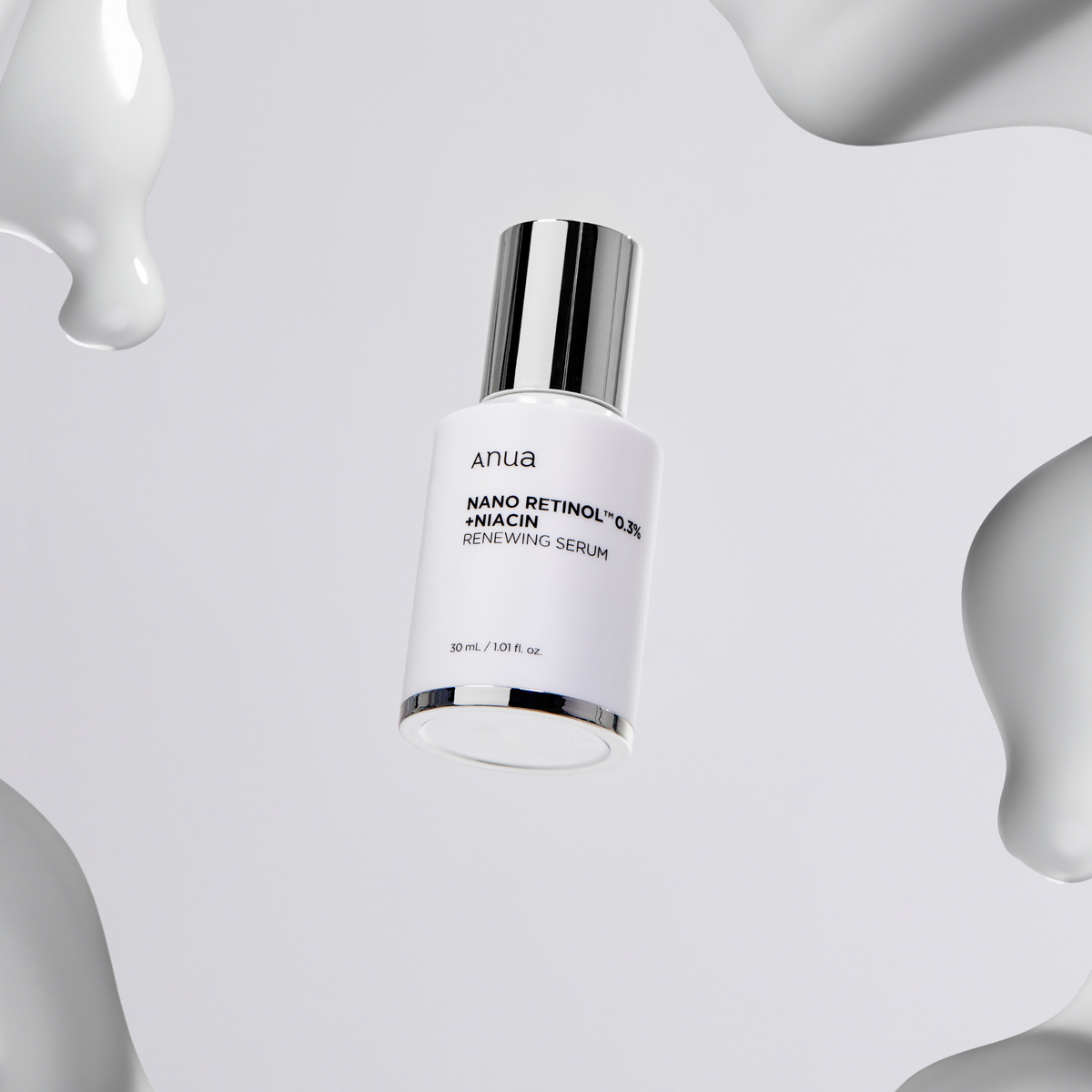Flacon de sérum blanc entouré de gouttes crémeuses