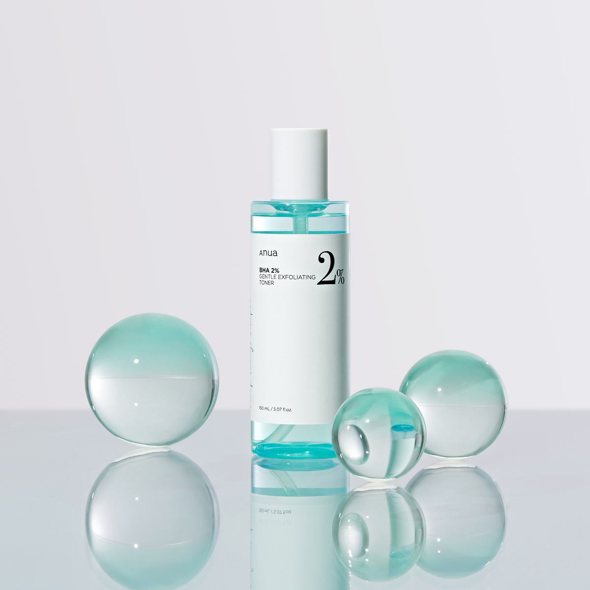 Flacon de lotion bleutée entouré de sphères transparentes