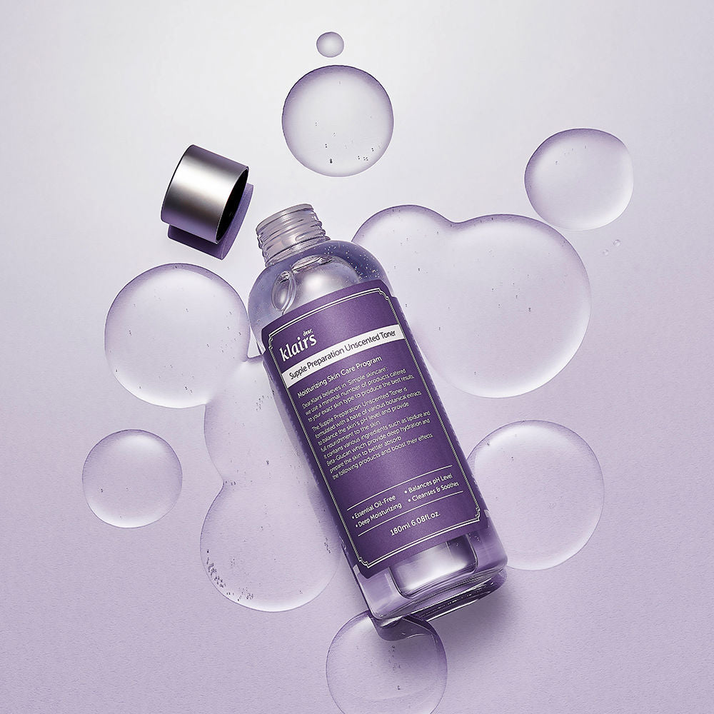 Flacon de lotion ouvert au milieu de gouttes transparentes sur fond mauve