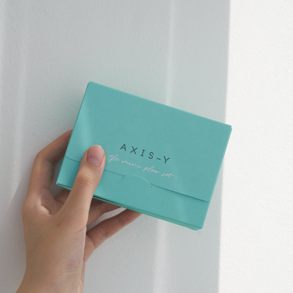 Petit coffret turquoise fermé tenu dans la main