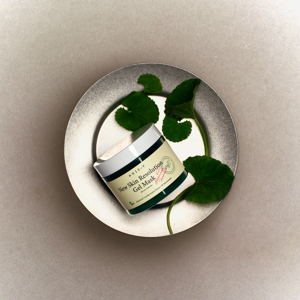 Pot de masque entouré de feuilles sur une assiette métallique