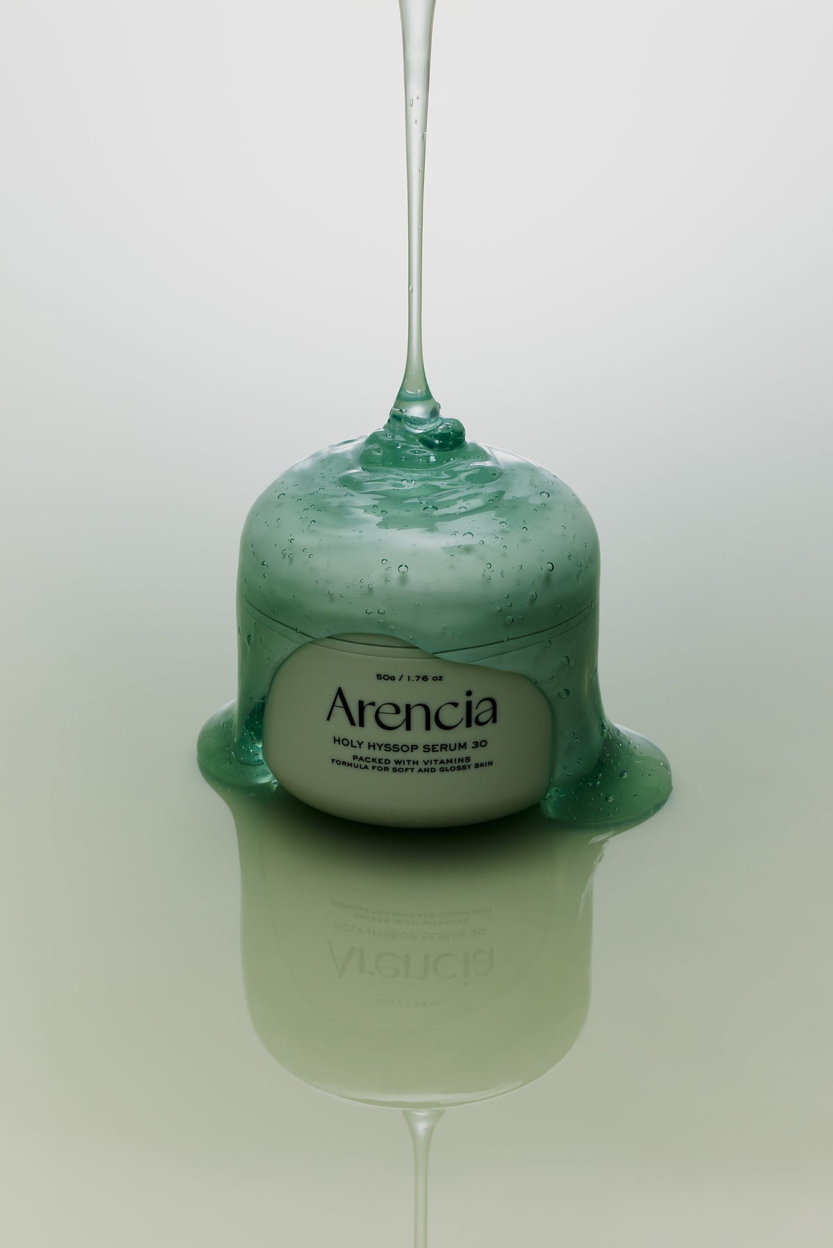 Gel vert filant coulant sur le pot de sérum