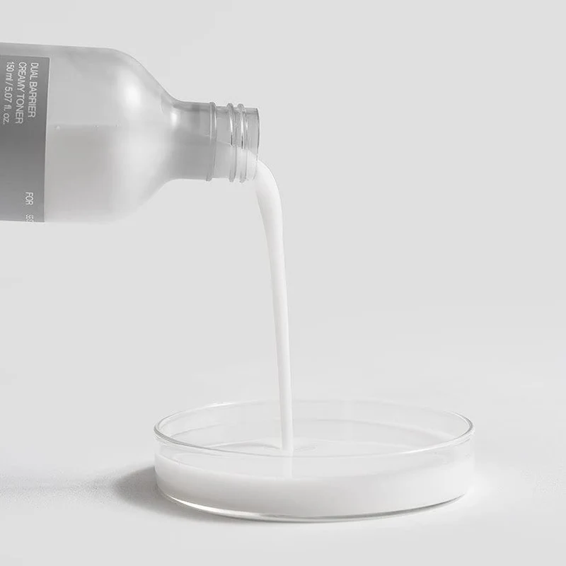 Lotion laiteuse versée dans une coupelle transparente