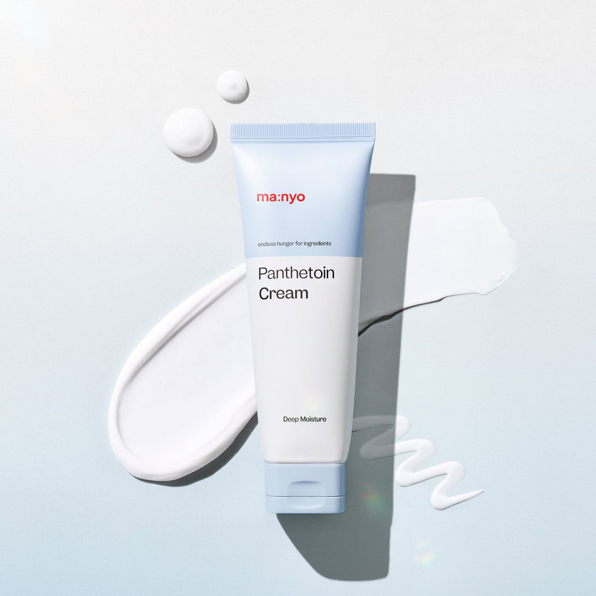 Tube de crème entouré de gouttes et de traces blanches