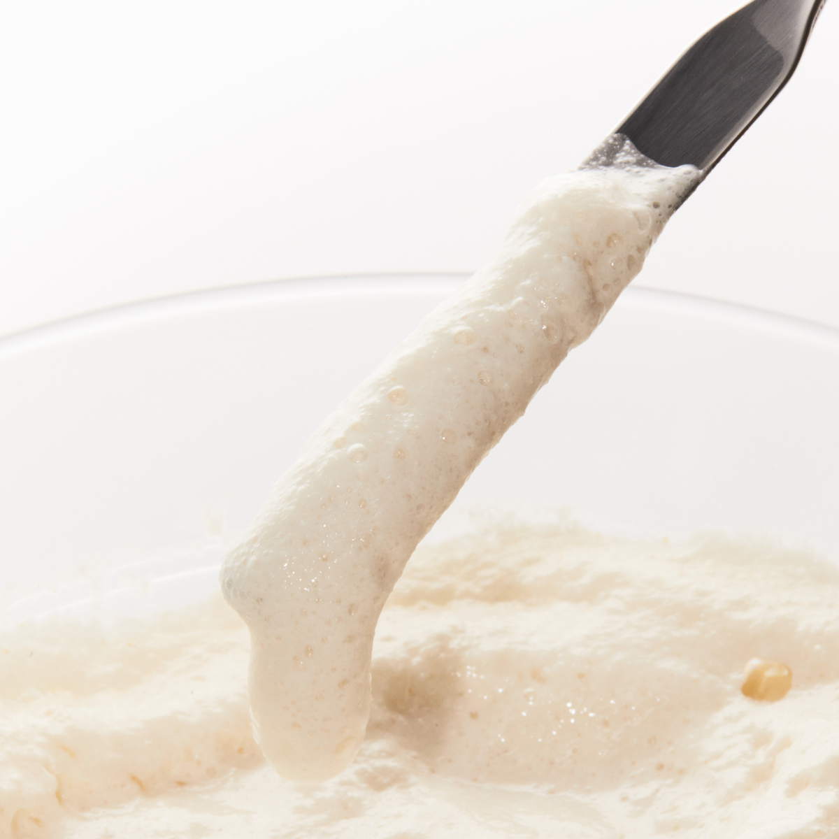 Pâte nettoyante beige prélevée avec une spatule
