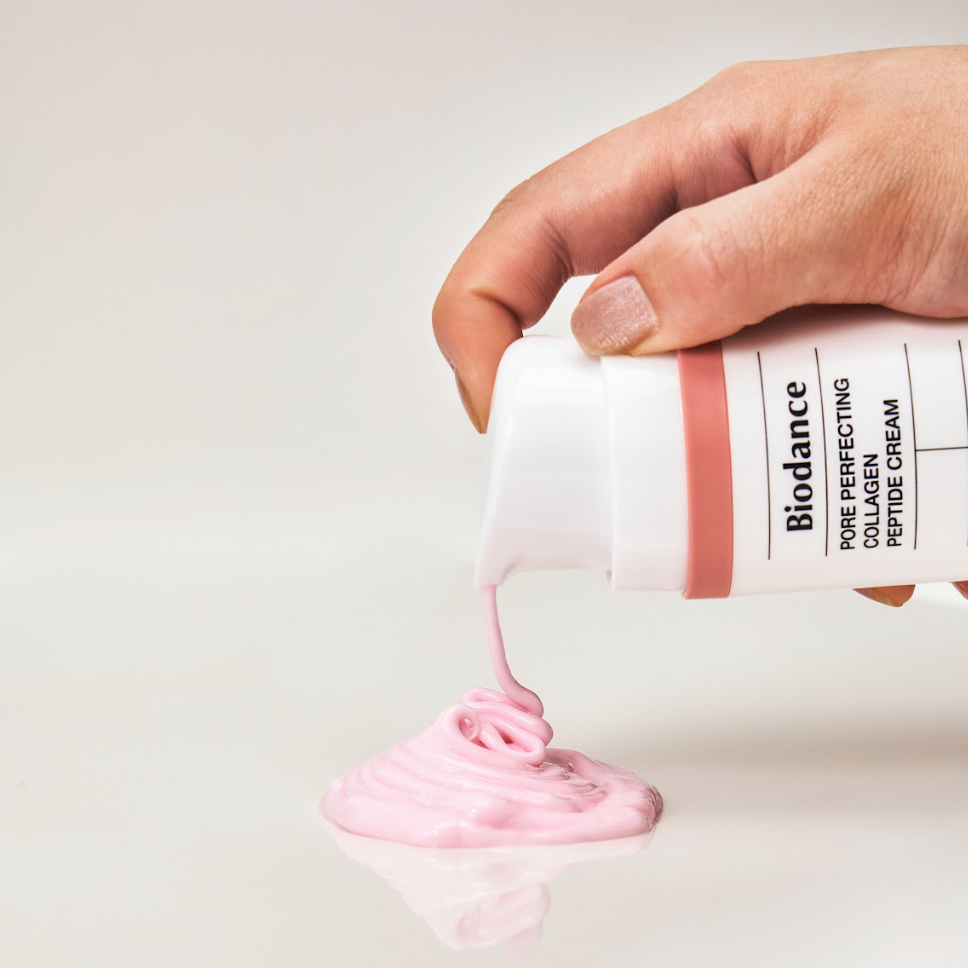 Crème rose distribuée par le flacon-pompe sur une surface claire