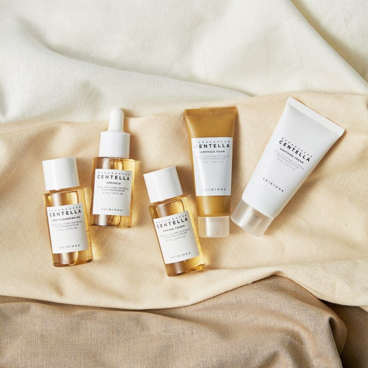 Cinq miniatures de la gamme centella posées sur un tissu beige