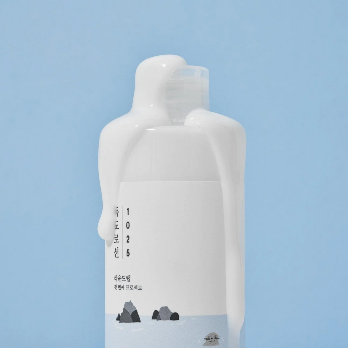 Flacon blanc de lotion couvert de texture laiteuse