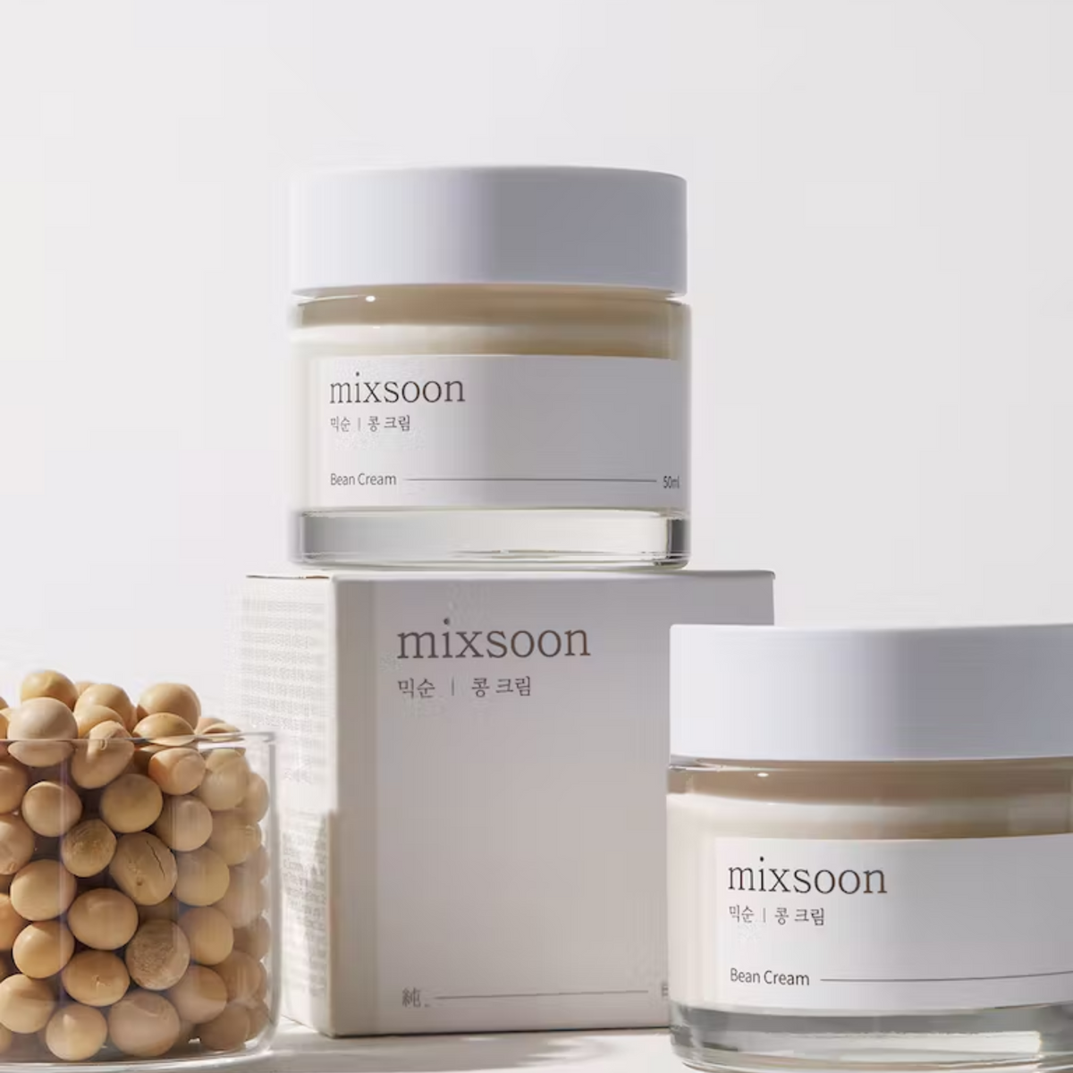 Pots de crème avec leur boîte près de graines de soja