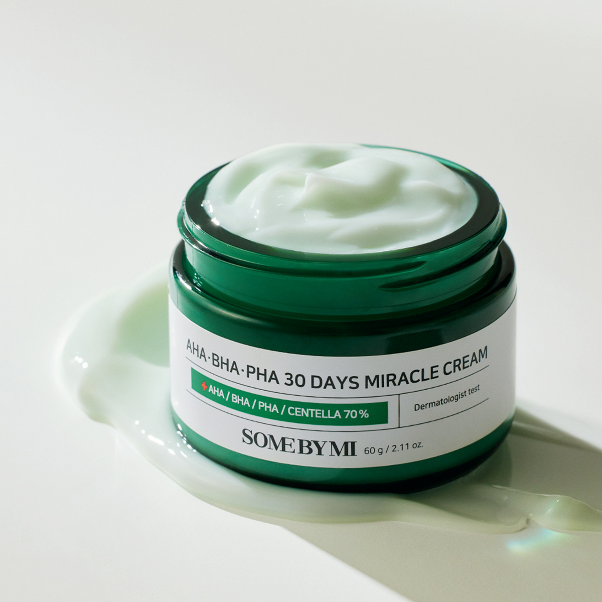 Pot vert ouvert sur une crème vert pâle avec une trace de texture