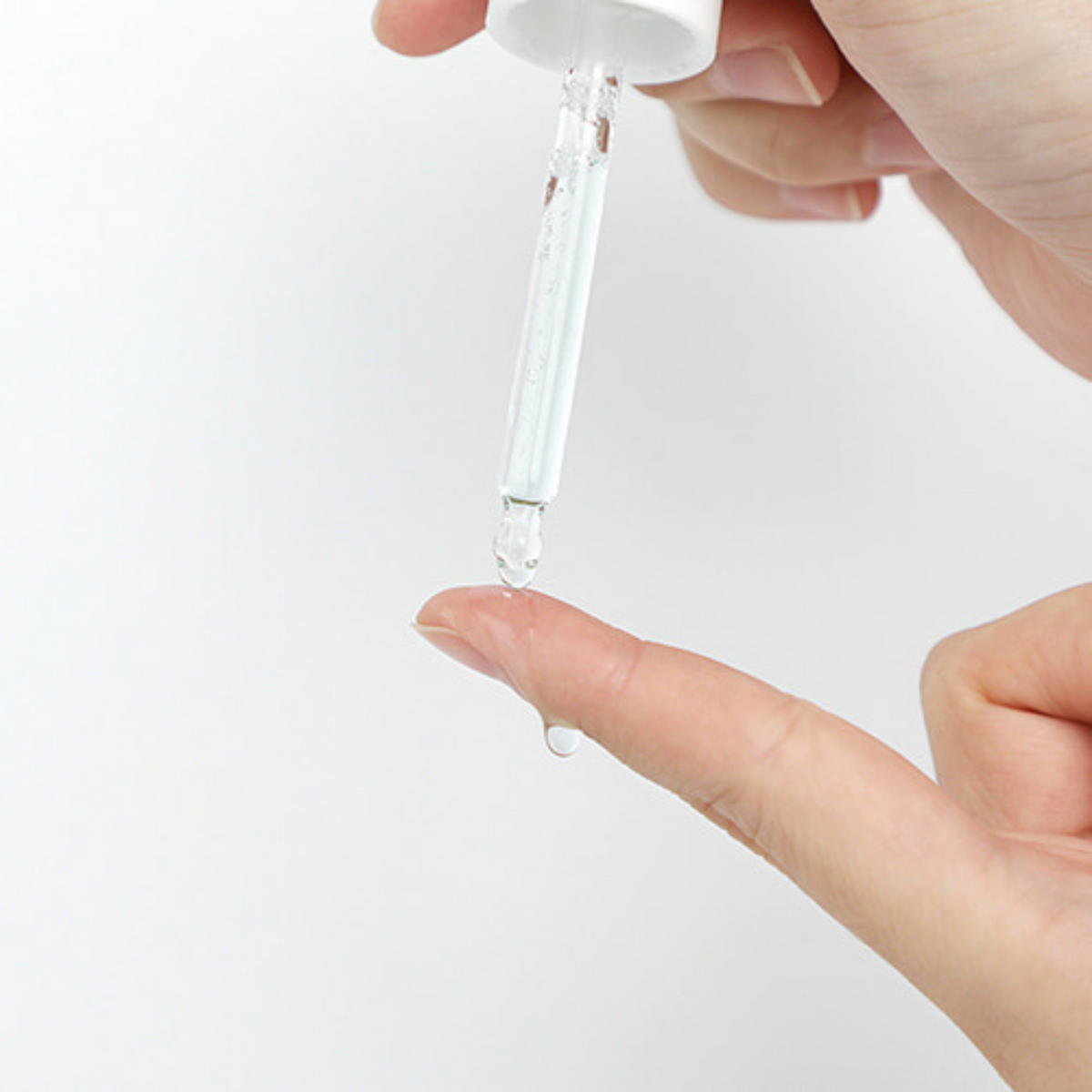 Sérum transparent déposé à la pipette sur le bout du doigt