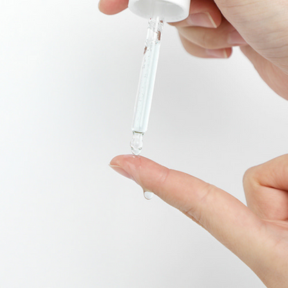 Sérum transparent déposé à la pipette sur le bout du doigt
