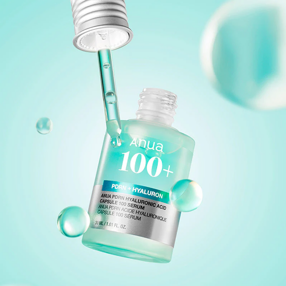 Pipette et flacon de sérum bleu-vert entourés de gouttes