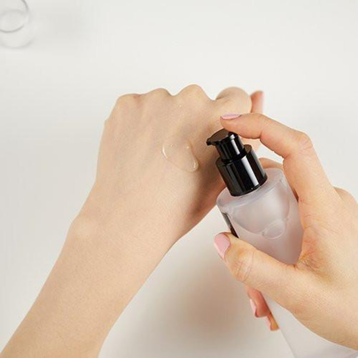 Lotion transparente distribuée sur le dos de la main avec la pompe