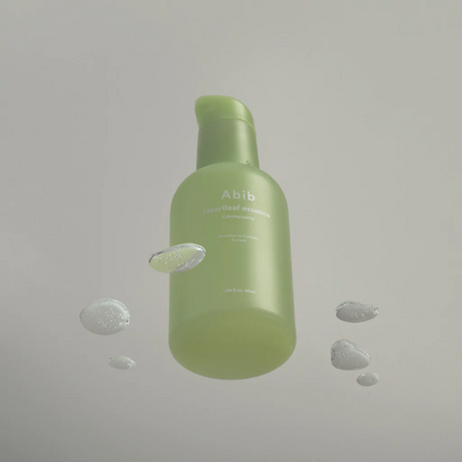 Flacon-pompe vert entouré de gouttes de gel transparent