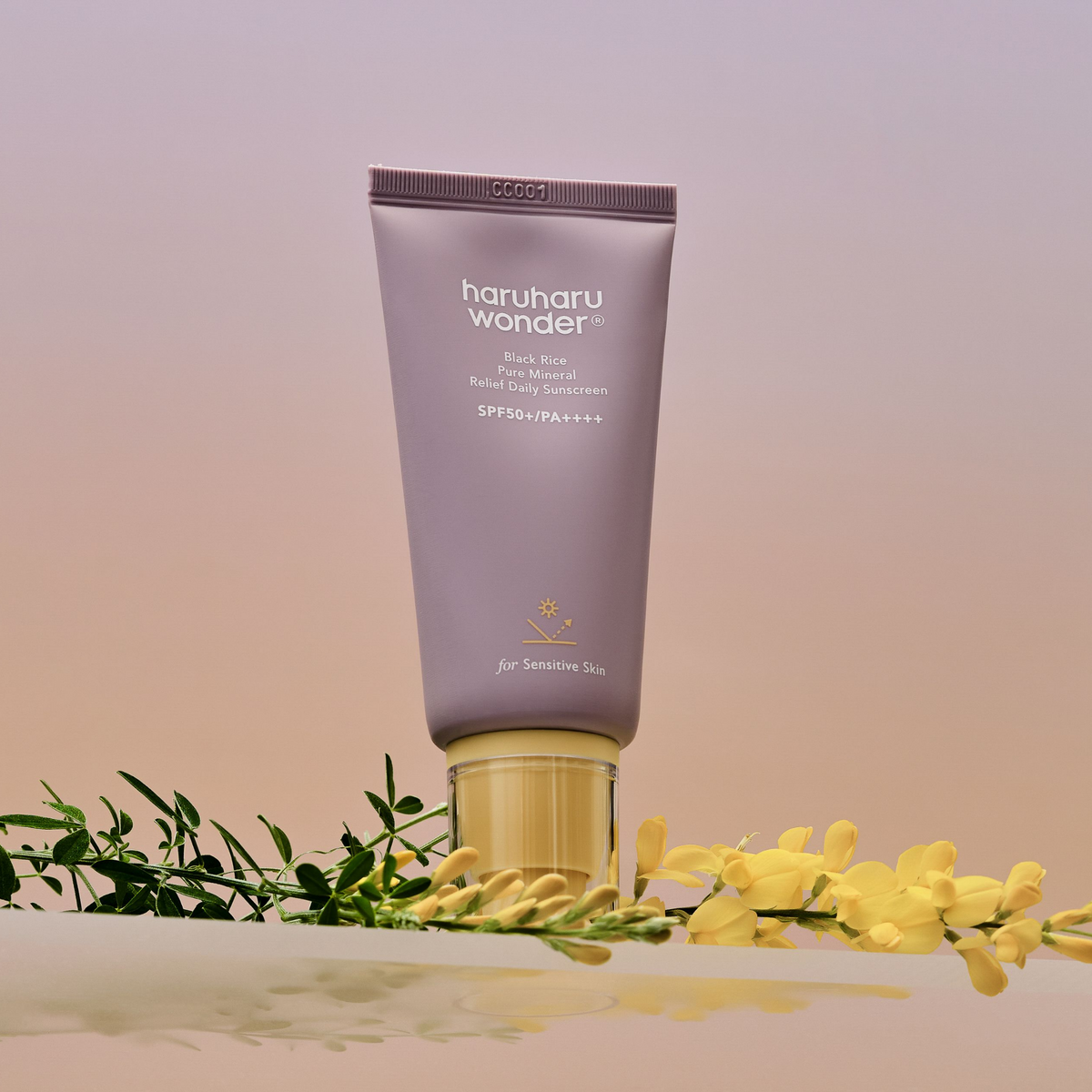 Tube mauve de solaire à bouchon jaune près de fleurs jaunes