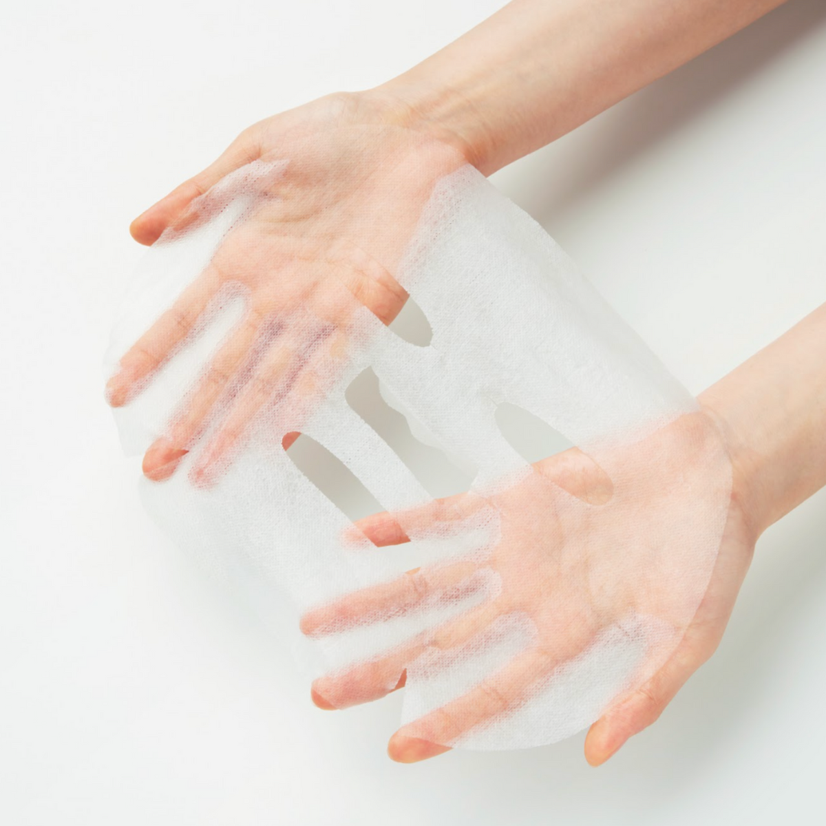 Masque en tissu blanc déplié entre les deux mains
