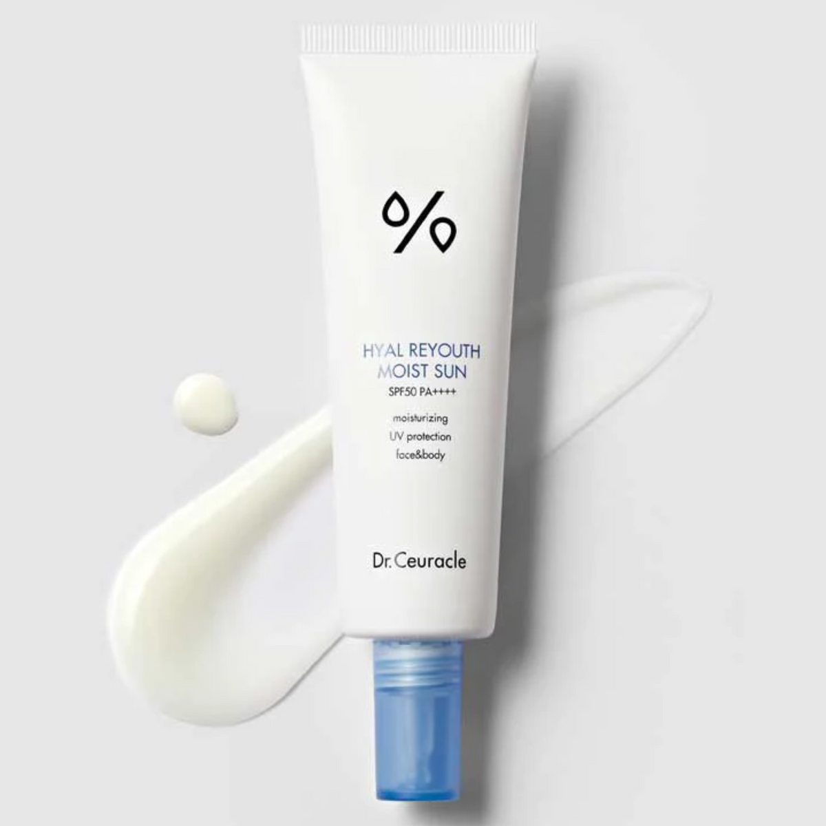 Tube blanc à bouchon bleu posé près de traces de crème solaire
