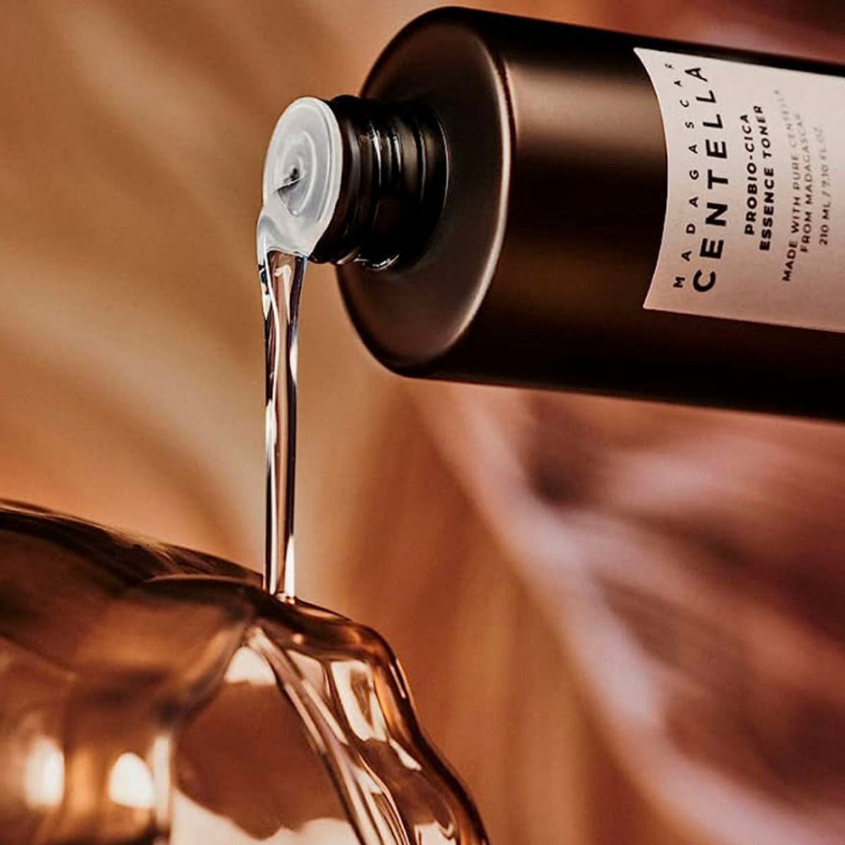 Lotion transparente versée depuis le flacon brun sur du verre