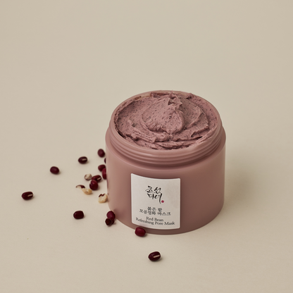 Pot ouvert de masque rose brun entouré de haricots rouges