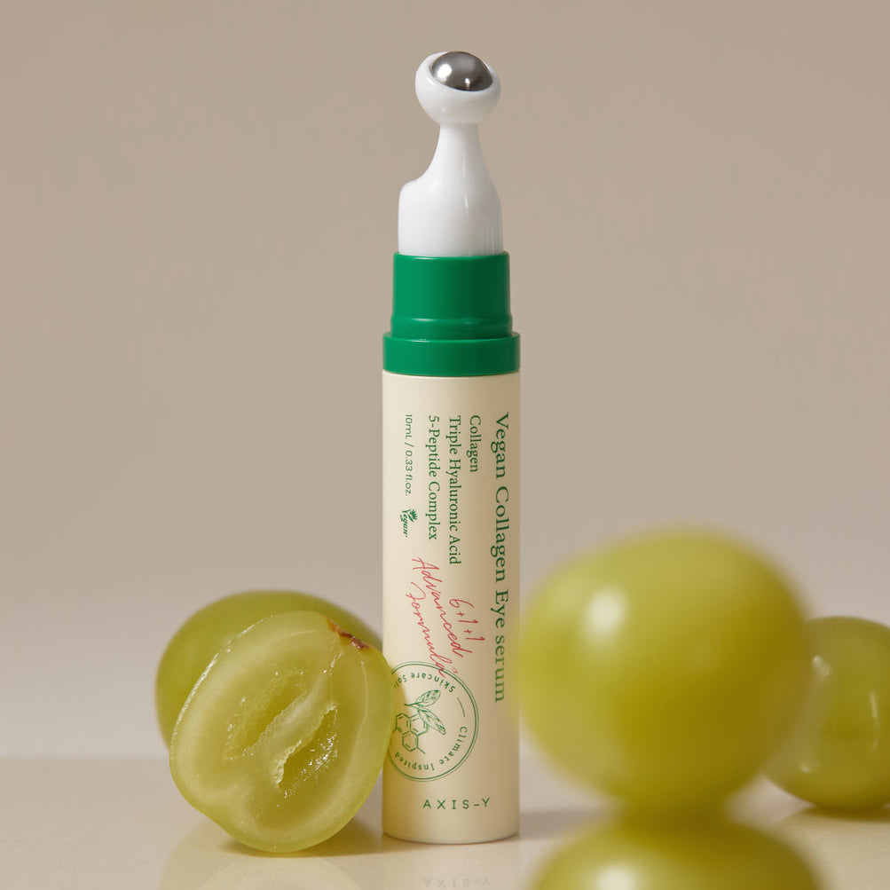 Applicateur à bille métallique du contour des yeux présenté près de raisins verts