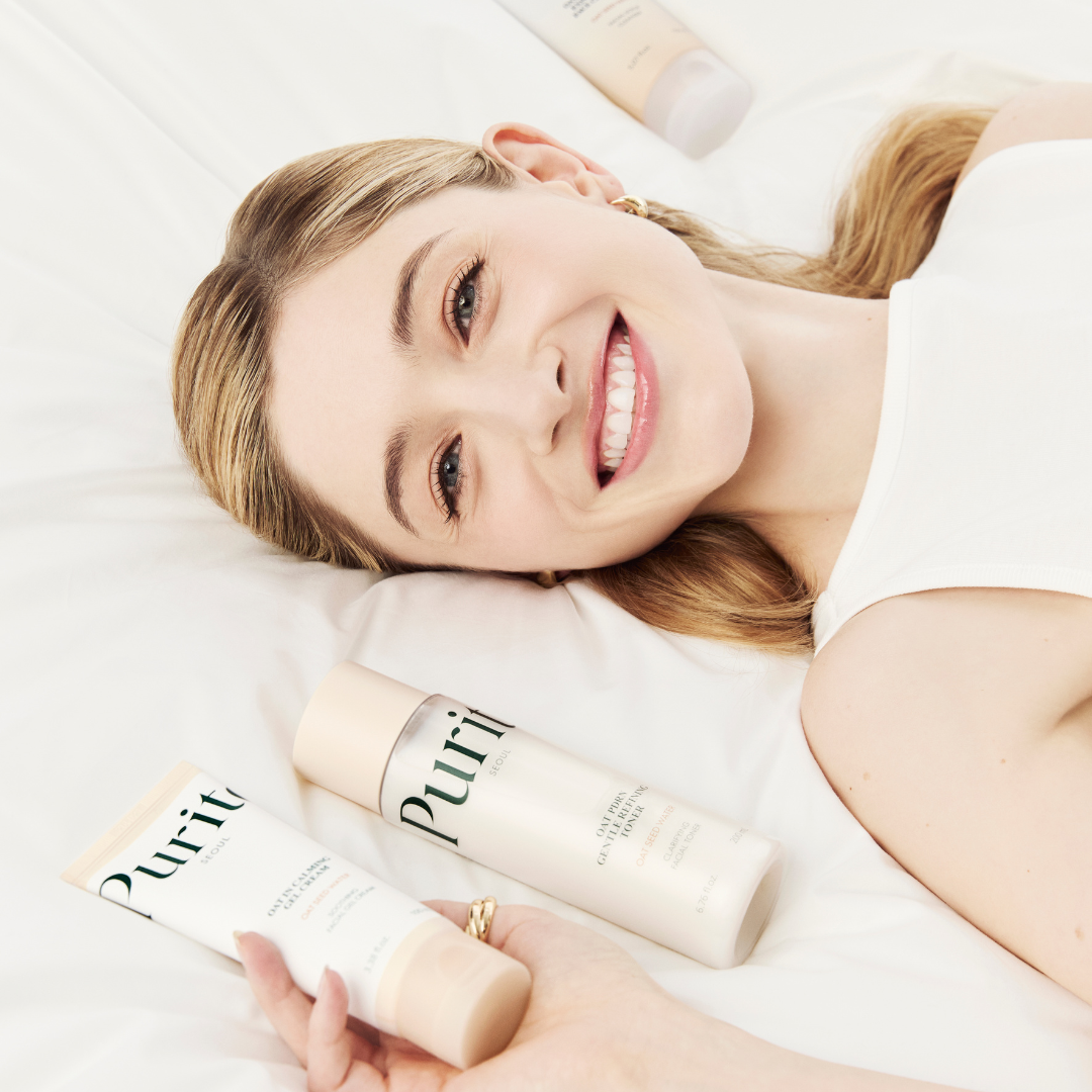 Soins de la gamme avoine présentés sur une literie blanche près du visage