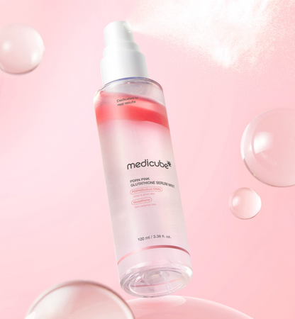 Brume fine pulvérisée au-dessus du flacon à phase rose