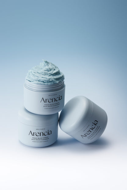 Pots bleus de nettoyant, dont un ouvert sur une pâte bleue fouettée
