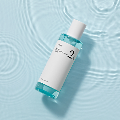 Flacon de lotion bleutée posé dans de l&