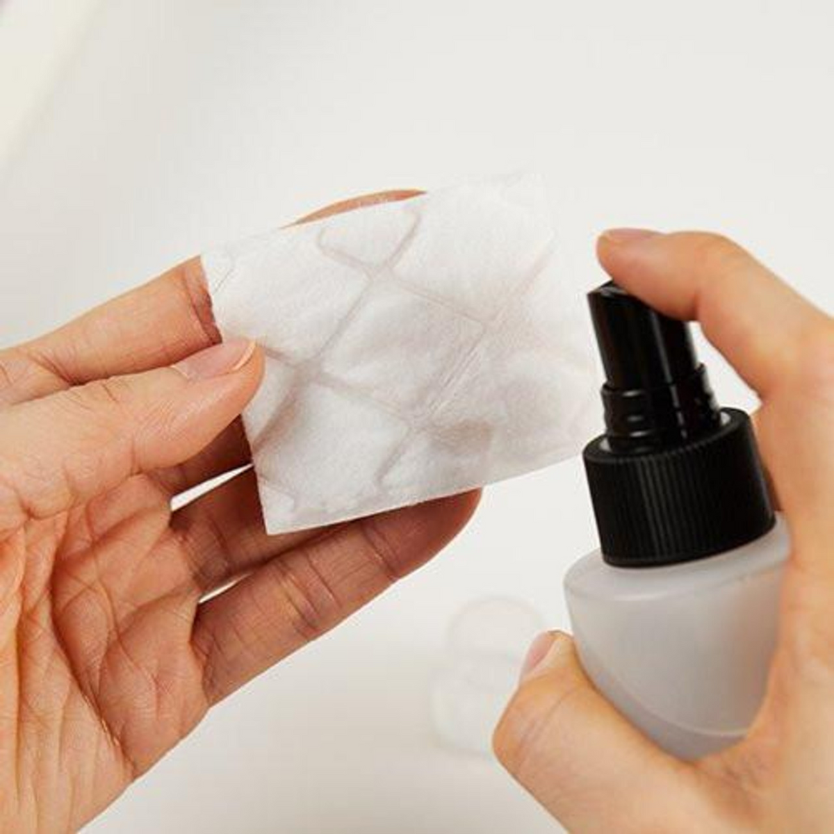 Lotion vaporisée sur un carré de coton