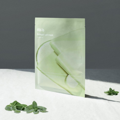 Sachet vert de masque dressé près de petites feuilles