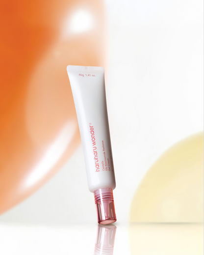 Tube fin de gel-crème à bouchon rose sur un fond orange et blanc